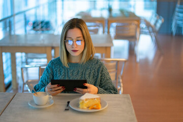 Female higher education student looking at digital tablet in university cafe