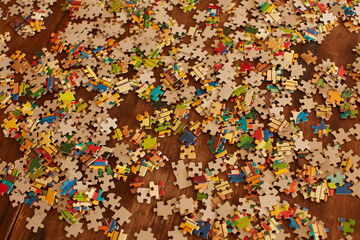 Jigsaw puzzle pieces on wooden floor