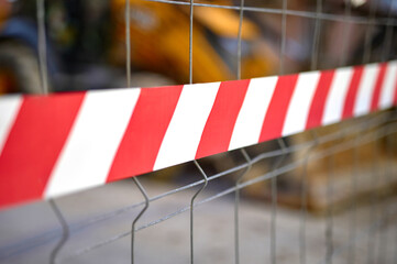 white and red marking tape marking a public construction site on