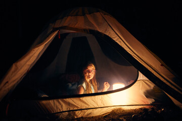 Girl inside tent at night