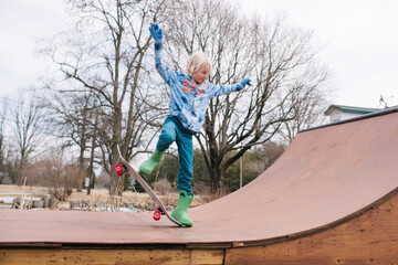 Boy on rural skateboard ramp practicing skateboarding trick