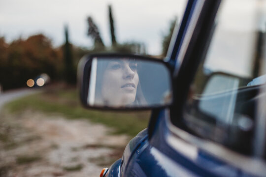 Mirror image of woman driving car © Image Source