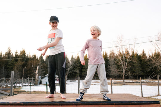 Boy and sister dancing on top of rural concrete slab