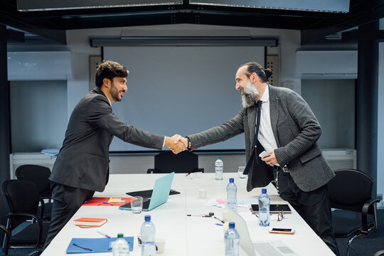 Business partners shaking hands at meeting in office