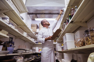 Chef checking stock of goods in storage room