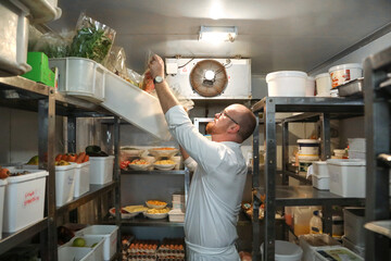 Chef checking stock of goods in storage room