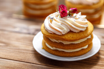 Sponge cake with cream, decorated with small flowers.