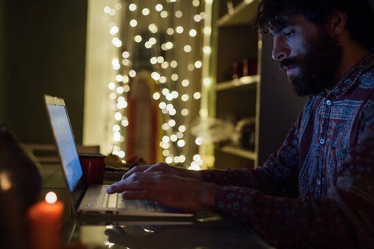 Bearded young man using laptop at home