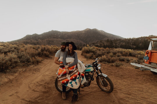 Couple relaxing on motorbike, Kennedy Meadows, California, US