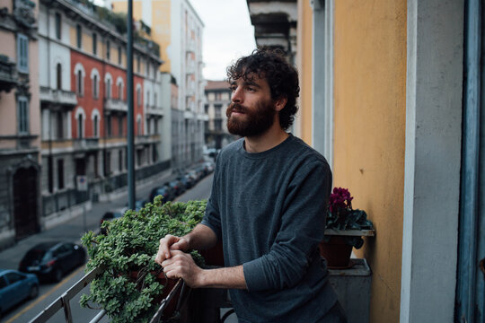 Bearded young man in deep thought on balcony