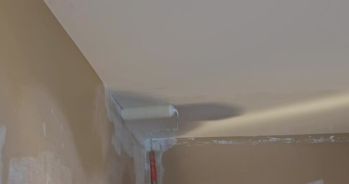 Painting of ceiling in a primer on white color repair in a house for painting walls