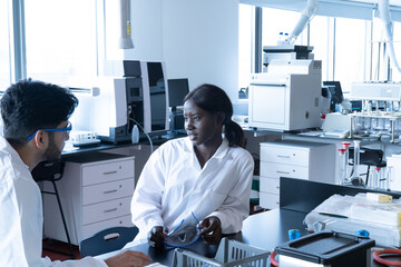 Young female and male scientists having discussion in laboratory