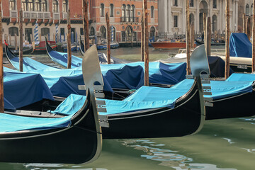 Fototapeta na wymiar Gondolas parked on the Grand Canal near the Rialto Bridge in Venice, Italy. Travel concept.