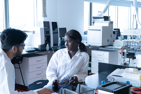 Young female and male scientists having discussion in laboratory
