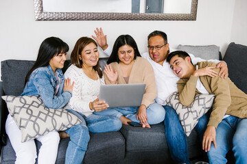 latin family in a video conference on laptop at home in Mexico