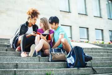 cute group of teenages at the building of university with books huggings, diversity nations, having lunch