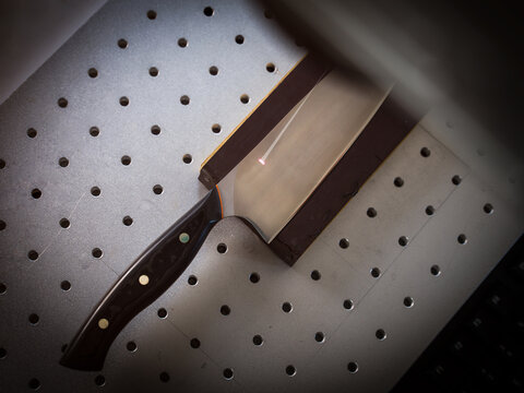 Knife under laser cutting equipment in workshop, overhead view