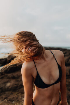 Swimmer by seaside enjoying wind in hair