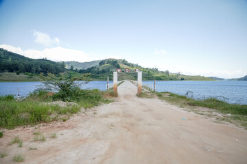 Obraz premium Um portal para entrada da represa para pescadores com lateral para aguas cristalinas e fundo da montanhas.