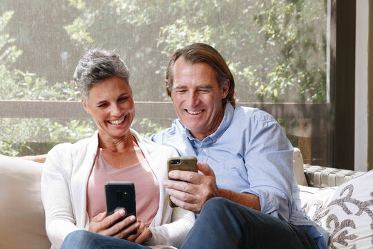 Couple laughing at cellphone messages