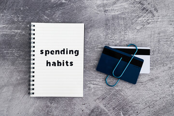 spending habits text on notepad with payment cards next to it, money and consumer behaviour