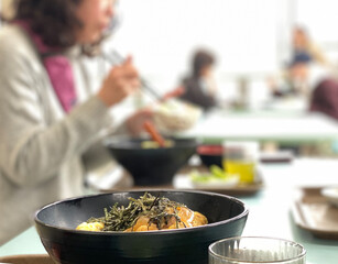 食堂で女性が食事をする風景