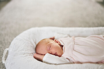 Baby sleeping on U-shaped pillow at home