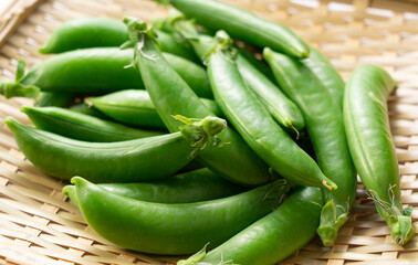 Snap peas placed on a bamboo colander.