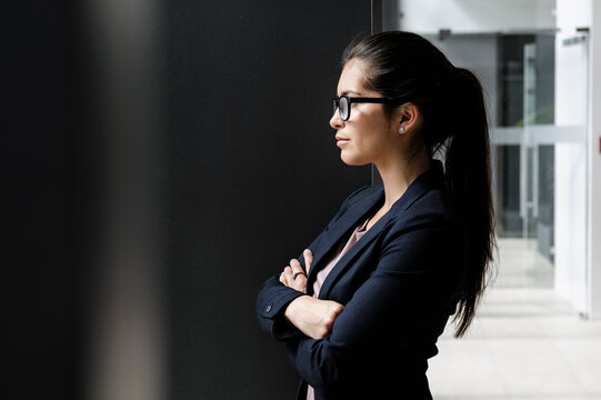 Young businesswoman taking break at corridor of office building