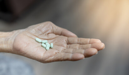 The senior man hands putting pills in his hand. The Old man taking care himself for health. Health and Medical concept.