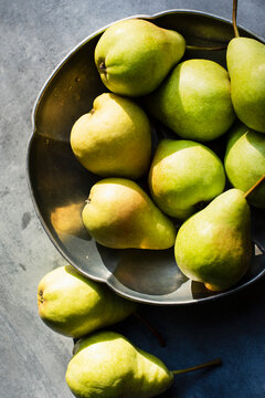 Still life of pears in metal bowl in sunlight 
