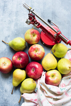 
Apple peeler with apples and pears on table