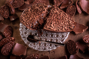 Cracked stuffed chocolate easter egg with grated chocolate on the top and lots of mini easter eggs...