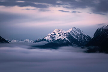 A cloudy inversion fills the valley in Banff National Park as the clouds and mountains reflect the...