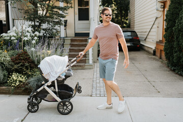 Father pushing baby carriage on pavement