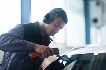 Workman fixing car windshield in workshop