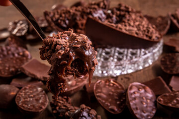 Close up of a spoonful of a cracked stuffed chocolate easter egg with grated chocolate on the top...