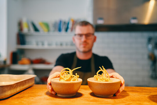 Waiter placing food on service counter in restaurant