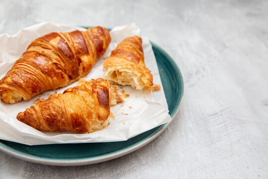 Plate of croissants, whole and broken in half