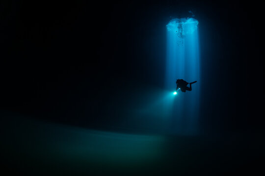Divers exploring Cenote Maravilla, Mexico