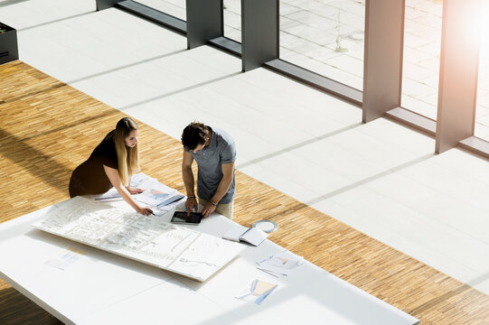 High angle view of two young architects working on an architectural model.