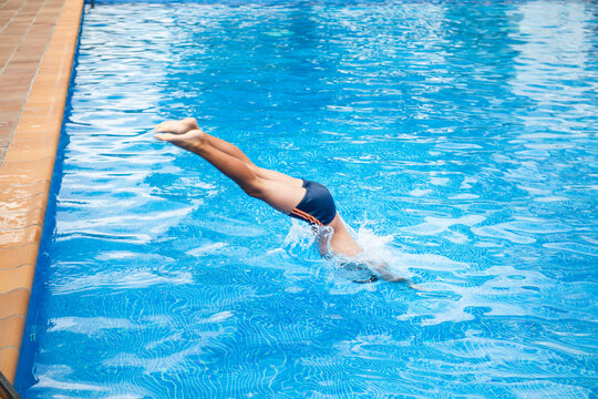 High angle view of boy diving into outdoor swimming pool.