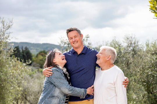 Senior couple with son, olive trees in background, Florence, Italy