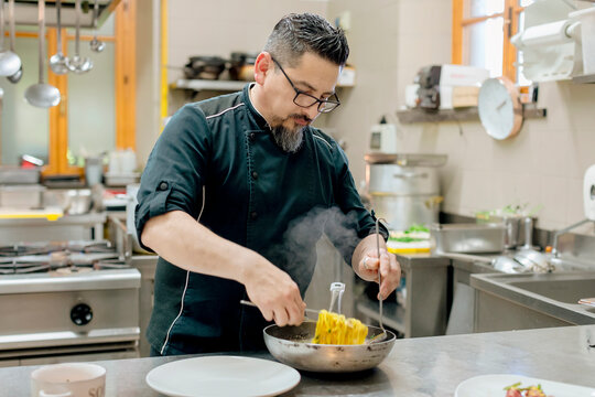 Chef preparing pasta in kitchen
