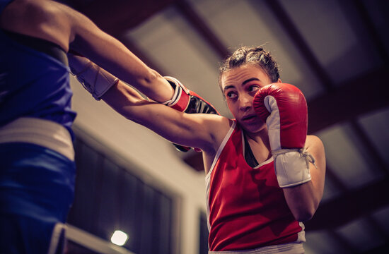 Low angle view of female boxer wearing red boxing gloves. - Powered by Adobe