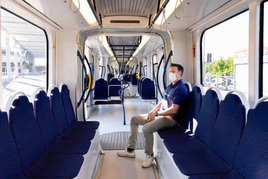 Man wearing face mask sitting in an empty train in Florence, Italy during the Corona virus crisis.