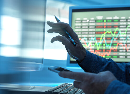 Close up of stock market trader analysing share price data on the screen.