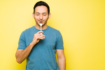 Man with cravings eating tasty food with a fork
