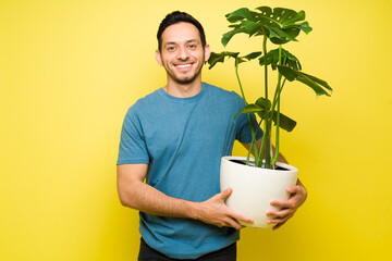 Portrait of a smiling man taking care of a houseplant