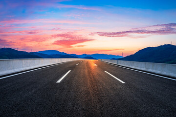 Country road and mountain in summer at sunset.